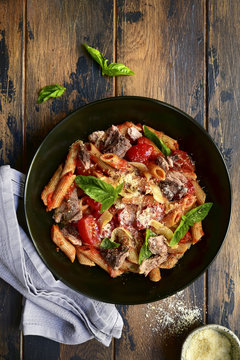 Wholegrain penne pasta with tomato and tuna in red sauce.Top view.