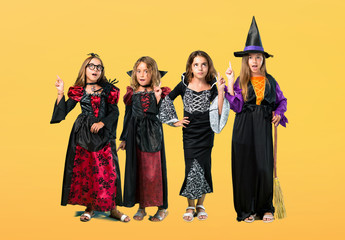 Naklejka premium Set of Little girl dressed as a vampire for halloween holidays standing and thinking an idea on orange background