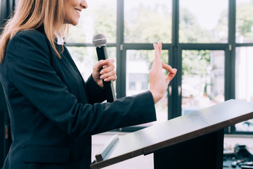 Fototapeta premium cropped image of lecturer showing okay gesture at podium tribune during seminar in conference hall