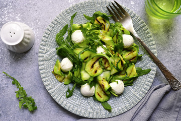 Grilled zucchini salad with arugula and mozzarella balls.Top view.