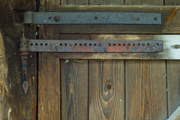 Rusty door hinges on the door of the barn