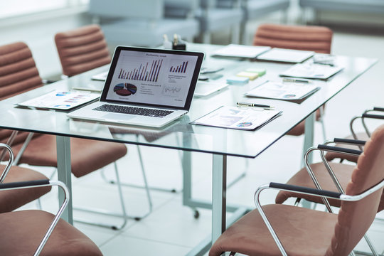  Open Laptop Computer With Financial Charts And Papers Spread Out On The Desktop Before Starting Business Negotiations