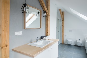 Bright modern bathroom with grey walls, mirror and bathtub.