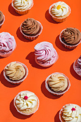 Colorful muffins on a bright orange background.