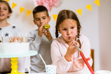 kids blowing party blower at birthday party