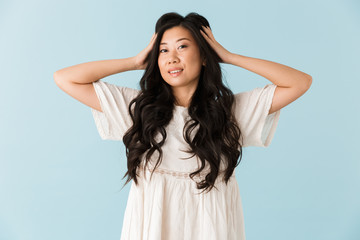 Fototapeta premium Happy young asian beautiful woman posing isolated over blue background.