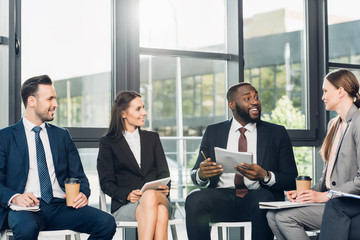 smiling multicultural businesspeople having meeting in conference hall
