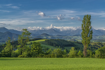 Vivid landscape with geen hills and high mountains