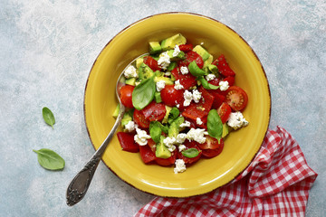 Vegetable salad with avocado, cherry tomato, grilled bell pepper and feta.Top view.