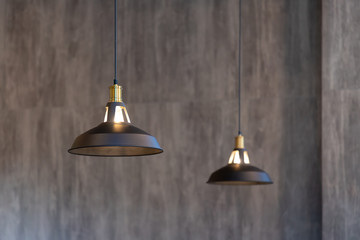 Obraz premium black metal hanging lamp on concrete wall.