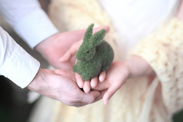 close up.couple in love holding a green toy rabbit.