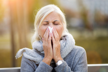 Sick woman blowing her nose
