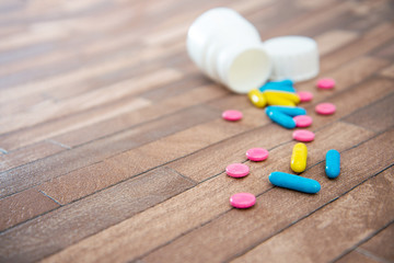 Medicine box and bottle on colorful pills