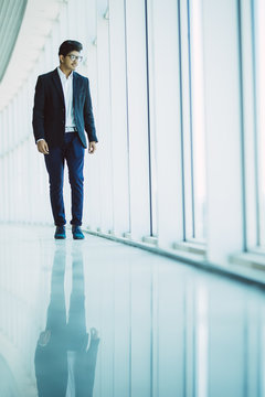 Business And People Concept. Young Indian Business Man Walking In Office Near Panoramic Windows,