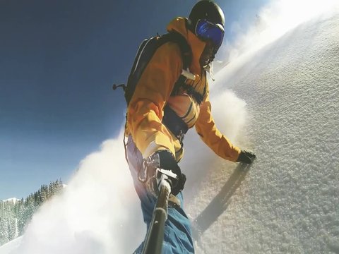 Point of view shot of Actionsportler snowboarder while freeride in remote area in Europe Alpes with action cam on selfie stick