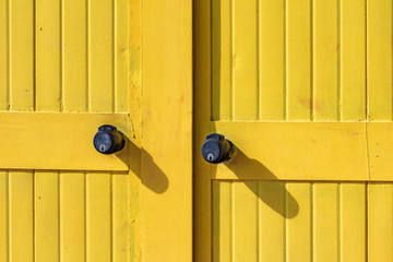 Beautiful yellow Bathing houses on sandy beach. Empty shelters on a sunny but moody day. Seaside...