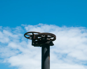 old handwheel of valve in a sky background