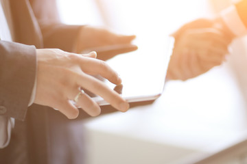 Obraz premium businessman with digital tablet in the background of handshake