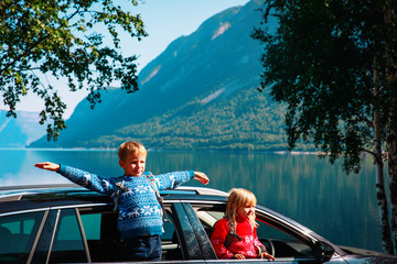 happy little boy and girl enjoy travel by car in nature