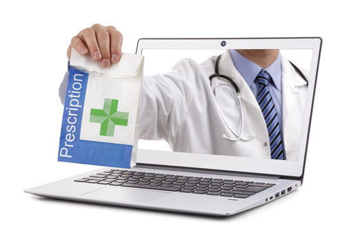 Internet drug store pharmacy concept doctor holding prescription medicine through a laptop screen