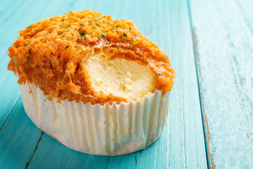 side view shredded pork bread with a bite on blue wood background