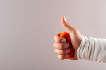 hurt hand doing rehabilitation exercises by squeezing an O ring hand trainer