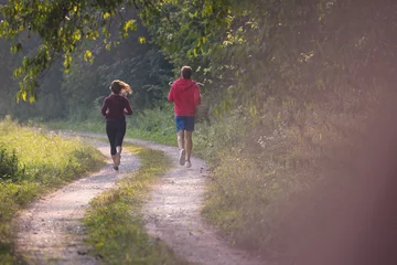 Papier Peint photo autocollant Jogging young couple jogging along a country road