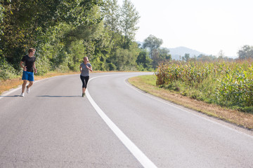 Obraz premium young couple jogging along a country road