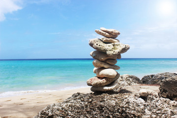 Fototapeta na wymiar Lanscape of pebbles stacked up against blue sky and ocean