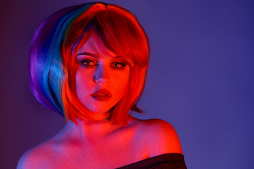 High Fashion girl model with trendy make-up in colorful bright lights. Woman portrait in red and blue colors.