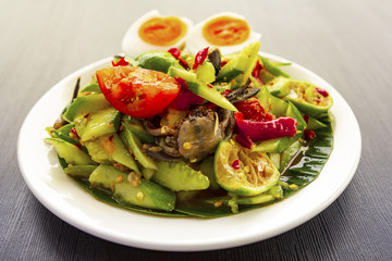 Spicy cucumber salad with boiled eggs on wood texture