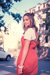 Fototapeta premium Open back. Appealing dark-eyed woman wearing dress with open back smiling broadly while enjoying her amazing weekend