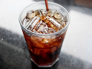 Cola in the glass with ice cubes on black table background, Drinks concept.