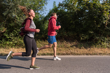 Obraz premium young couple jogging along a country road