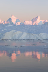 Beautiful iceberg in the pink and purple alpenglow light. Disko bay, Greenland.