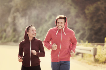 young couple jogging along a country road