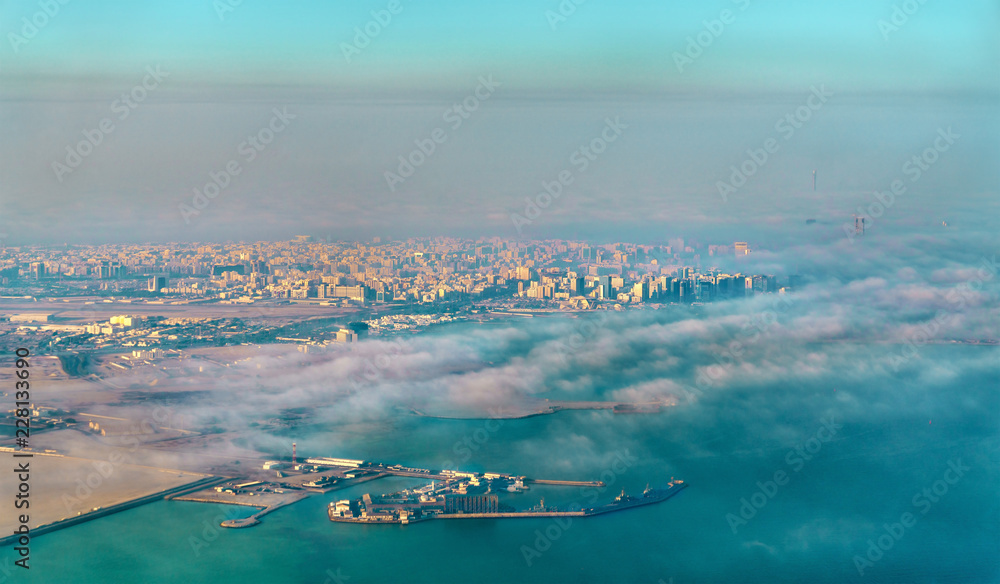 Sticker aerial view of doha through the morning fog - qatar, the persian gulf