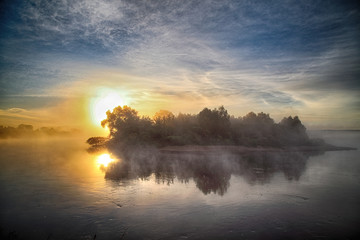 Obraz premium Fog over the river on a morning summer day. Beautiful scenery on the background of water with grass.