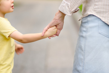 Beautiful granny and her little grandchild together walking