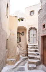 Fototapeta na wymiar Kleine und enge Straße in einem Dorf in Santorini