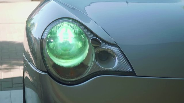 Front lamp of grey sport car goes on and off