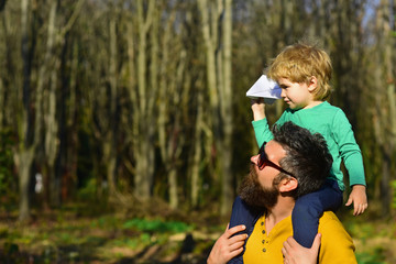 Father hold little son on shoulders with love. Loving father give child piggyback in park, love concept. Friends come and go, but family is always there