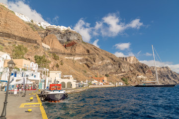 Obraz premium FIRA, SANTORINI, GREECE - JUNE 10, 2017: Tourists and tourist ship in the old port in Fira, Santorini
