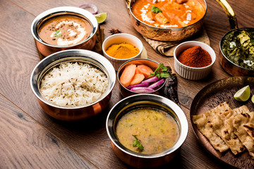 Indian Lunch / Dinner main course food in group includes Paneer Butter Masala, Dal Makhani, Palak Paneer, Roti, Rice etc, Selective focus