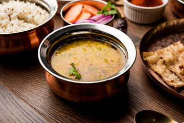 Dal Tadka Fry / Indian Lentil Curry served in a bowl with rice and roti, selective focus