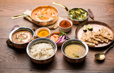 Indian Lunch / Dinner main course food in group includes Paneer Butter Masala, Dal Makhani, Palak Paneer, Roti, Rice etc, Selective focus