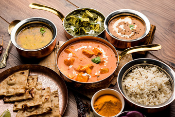 Indian Lunch / Dinner main course food in group includes Paneer Butter Masala, Dal Makhani, Palak Paneer, Roti, Rice etc, Selective focus