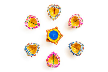 Happy Diwali - Clay Diya lamps lit during Dipavali, Hindu festival of lights celebration. Colorful traditional oil lamp diya on white background