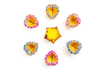Happy Diwali - Clay Diya lamps lit during Dipavali, Hindu festival of lights celebration. Colorful traditional oil lamp diya on white background