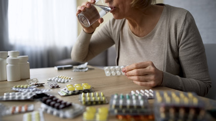 Senior lady obsessed with healthcare drinking too much pills medication overdose